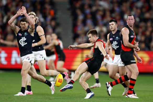 Zach Merrett of Essendon kicks.