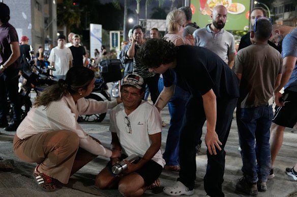 Residents console a man on the street after the twin quakes struck.