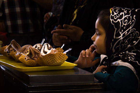 A young girl eyes dessert in Esfahan, Iran.