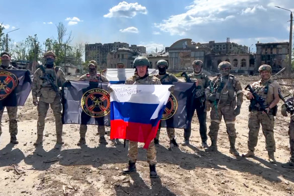 In this handout photo taken from video and released by Prigozhin Press Service Saturday, May 20, 2023, Yevgeny Prigozhin, the head of the Wagner Group military company speaks holding a Russian national flag in front of his soldiers in Bakhmut, Ukraine. 
