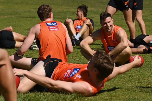Toby Greene and the GWS players stretch at Bronte Beach on Monday.