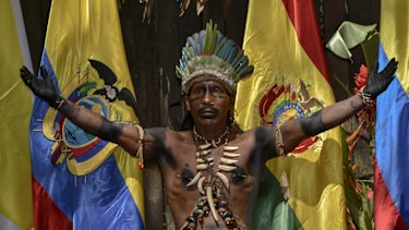 A Colombian Amazon tribesman gestures next to flags of Amazon nations during the Summit of Presidents for the Amazon on September 06.