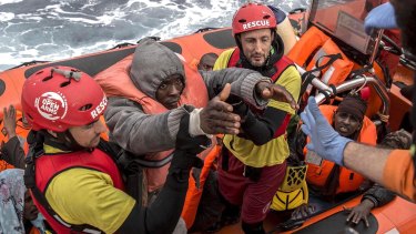 Refugees and migrants are transferred to a rescue ship by aid workers of the Spanish NGO Proactiva Open Arms, in February.