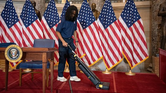 Un lavoratore pulisce il palco accanto a una sedia vuota dove il presidente Donald Trump avrebbe dovuto firmare un importante disegno di legge sull'edilizia abitativa.