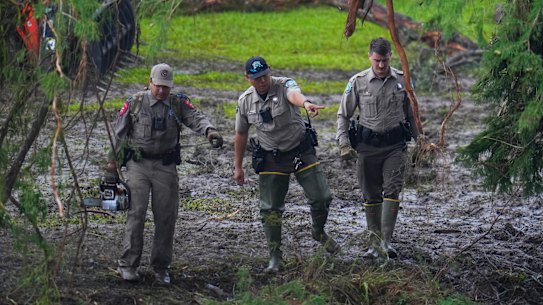 Officials inspect an area at Camp Mystic along the banks of the Guadalupe River in Hunt, Texas.