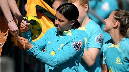 Sam Kerr signs autographs for young fans from the Mt Gravatt Hawks just before Matildas training on Sunday.