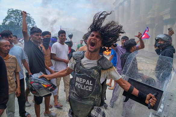 A protester wearing flak jacket and carrying a shield snatched from a policeman shouts slogans at the Singha Durbar, the seat of Nepal’s government’s various ministries and offices during a protest against social media ban and corruption in Kathmandu.