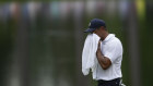 Tiger Woods wipes his face on the 16th hole.