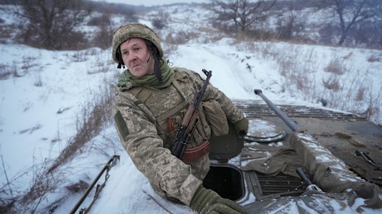 A Ukrainian serviceman looks back from atop an armored personnel carrier driving near a front line position in the Luhansk area, eastern Ukraine.