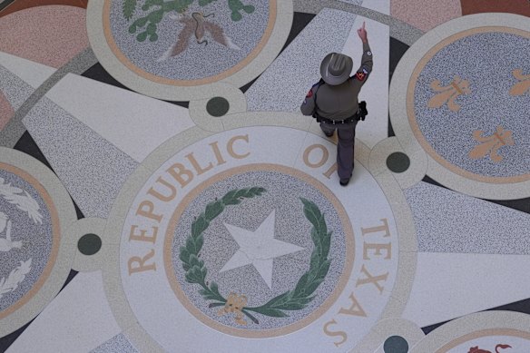 A Texas troopers passes the Texas Seal on the Rotunda of the Texas Capitol before debate on a bill for a redrawn U.S. congressional map during a special session in the Senate Chamber in Austin.