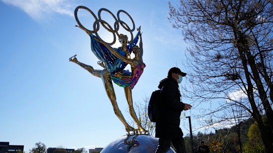 A visitor to the Shougang Park walks past the a sculpture for the Beijing Winter Olympics in Beijing, China.
