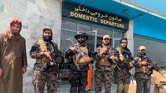 Taliban fighters stand guard inside the Hamid Karzai International Airport the day after US forces departed. 