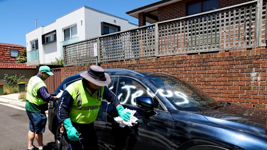Randwick council cleaners remove antisemitic graffiti from a car on Sunday after a spate of attacks on houses and vehicles in Sydney’s eastern suburbs.