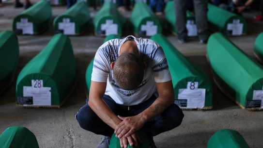 A Muslim man mourns next to the coffin of his relative, a victim of the 1995 Srebrenica genocide, in Potocari, Bosnia on Sunday