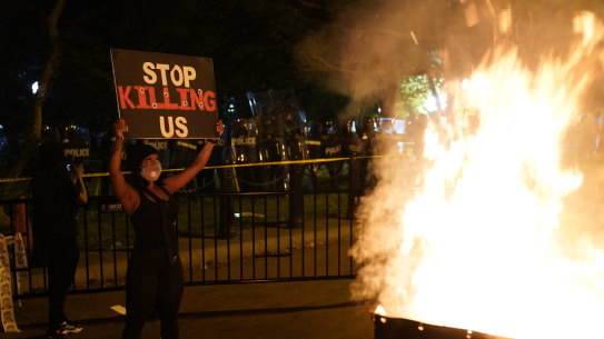 A fire burns in a dumpster as demonstrators protest the death of George Floyd near the White House in Washington. 