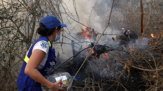 A volunteer works to put out a fire in Aguas Calientes on the outskirts of Robore, Bolivia, on Saturday.