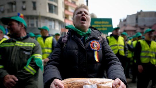 A woman holds a loaf of bread during a farmers’ protest in front of the Representative Office of the European Commission in April.