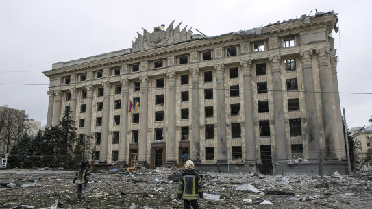 A member of the Ukrainian Emergency Service looks at the City Hall building in the central square following shelling in Kharkiv, Ukraine, Tuesday, March 1, 2022. 