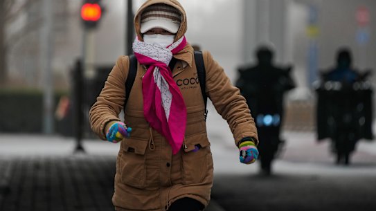 A woman runs across a street Beijing on Monday.