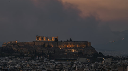 Smoke billows behind the Parthenon ancient temple on top of the Acropolis hill as a bushfire rages on the outskirts of Athens.