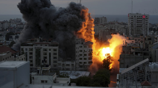 A ball of fire and smoke rise from an explosion on a Palestinian apartment tower following an Israeli air strike in Gaza City.