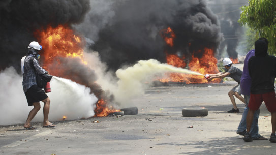 Anti-coup protesters put out fires during a protest in Thaketa, Myanmar, on Saturday.