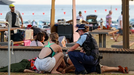 A police officer and a member of the public assist the victim.