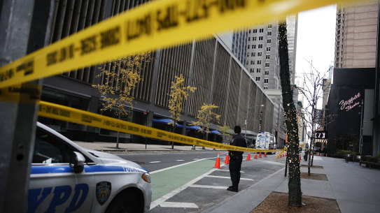 A New York police officer stands on 54th Street outside the Hilton Hotel in midtown Manhattan where Brian Thompson, the CEO of UnitedHealthcare, was fatally shot.