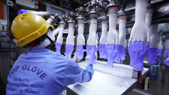 A worker inspects disposable gloves at the Top Glove factory in Shah Alam on the outskirts of Kuala Lumpur, Malaysia. 