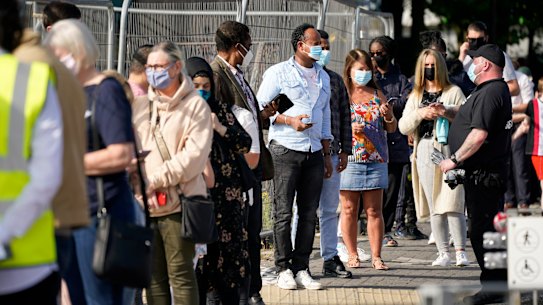 People queue at a walk-in COVID-19 testing centre in Bolton, in northern England. 