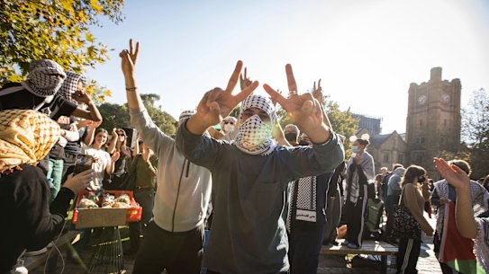 People dance at the pro-Palestine student protest as pro-Israel supporters encircle the camp.