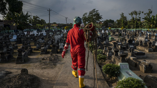 A volunteer prepares to conduct a burial the body of a woman suspected to have died from COVID-19 on Yogyakarta, Indonesia 