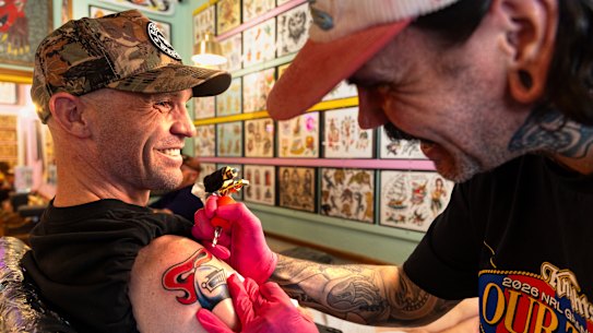 Mick Sharp gets a Newcastle Knights tattoo from artist Dave Ross at Electric Pantera Tattoo Parlour in Newcastle on Thursday.