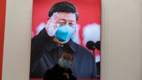 A child wearing a mask reacts near a photo showing Chinese President Xi Jinping at an exhibition on the city’s fight against the coronavirus in Wuhan in central China’s Hubei province.