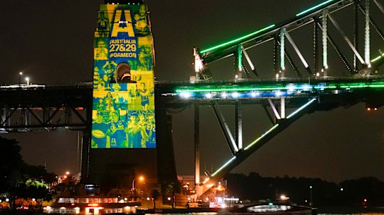 Sydney ferries sail past the illuminated pylon of the Sydney Harbour Bridge on Thursday night.