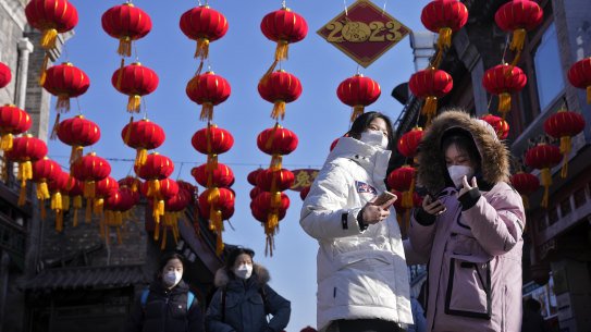 Visitors tour past red lanterns hanging on a shopping alley near the Houhai Lake for celebrating the Lunar New Year in Beijing on Monday.