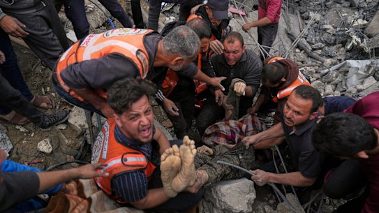 A dead man is removed from the rubble of the Manoun family’s house after it was targeted by an Israeli army strike in Jabalia al-Balad, Gaza City on Sunday.