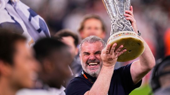 Tottenham’s head coach Ange Postecoglou holds up the trophy.