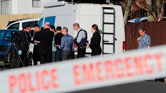 New Zealand police investigators work at a scene in Auckland after bodies were discovered in suitcases bought at storage place auction. 