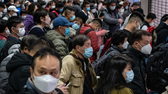 Travellers wait at a Hong Kong as tens of thousands surge into mainland China border as “COVID zero” ends after three years.