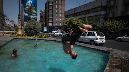 “Feels like” temperature recently reached 70 degrees in Iran. A young boy jumps into a pool to cool down at a square in downtown Tehran.
