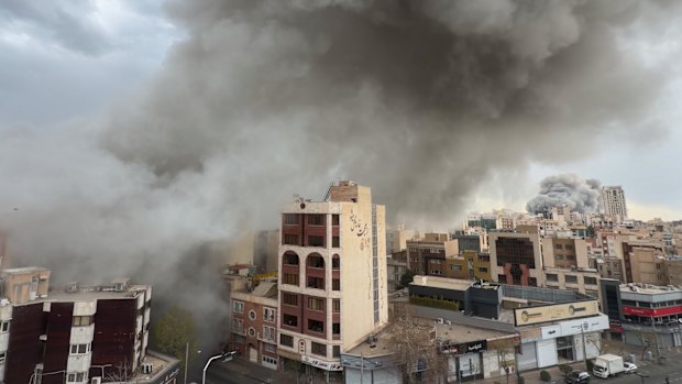 Plumes of smoke from two simultaneous strikes rise over Tehran on Monday.