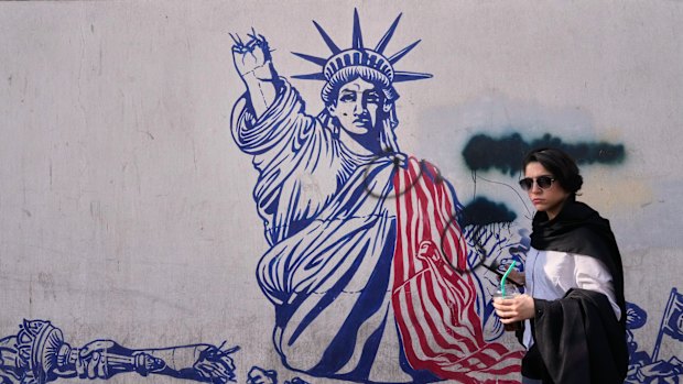 A woman walks past an anti-American mural on the wall of the former US embassy, now a museum, in Tehran, Iran on Friday.