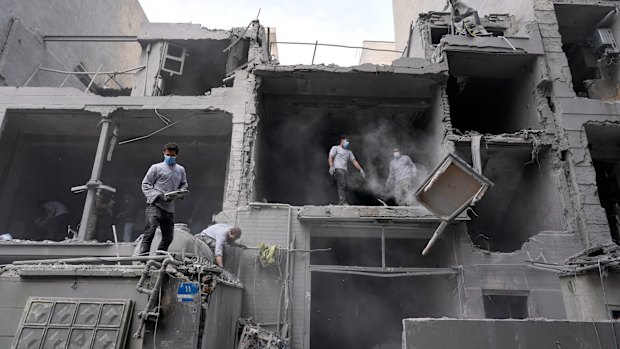 Volunteers clean debris from a residential building damaged when a nearby police station was hit Friday in a U.S.-Israeli strike in Tehran, Iran, Sunday, March 15, 2026. (AP Photo/Vahid Salemi)
