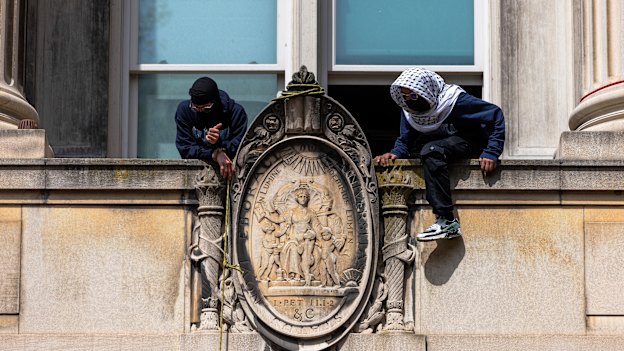 Pro-Palestinian protesters sit on a ledge as they occupy Hamilton Hall.