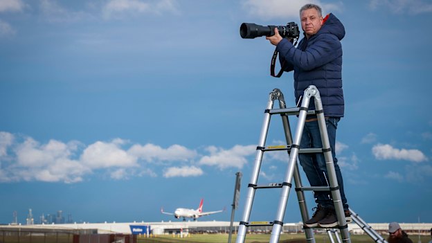 Plane spotter Kevin Alexopoulos, on his new ladder near Melbourne’s Tullamarine Airport, ready to take a dramatic photograph.