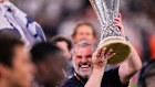 Tottenham’s head coach Ange Postecoglou holds up the trophy.