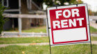 For rent sign in the yard in front of a house