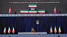 The coffins of the late Iranian Supreme Leader Ayatollah Ali Khamenei and members of his family are displayed on a platform above an empty chair