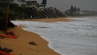 Waves reach the bottom of evacuated homes on the Central Coast ahead of the 2pm high tide.